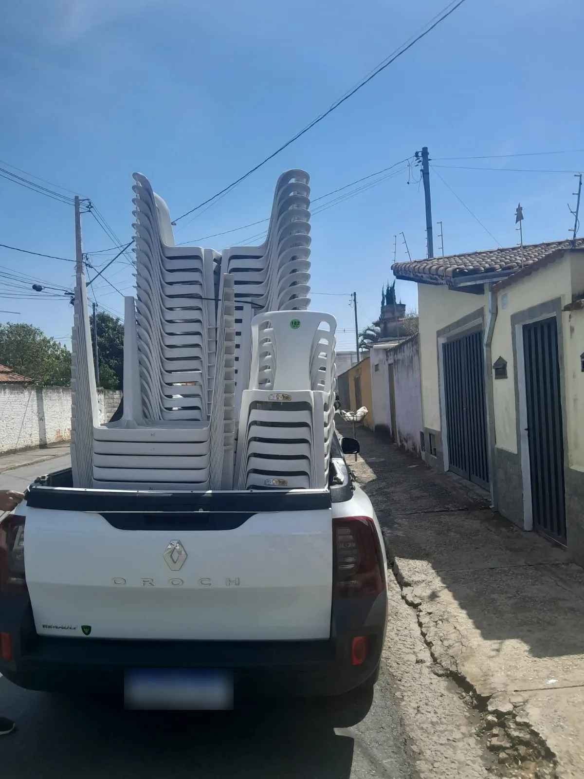 Picape da Giro Festas carregada de cadeiras para entrega em Pouso Alegre