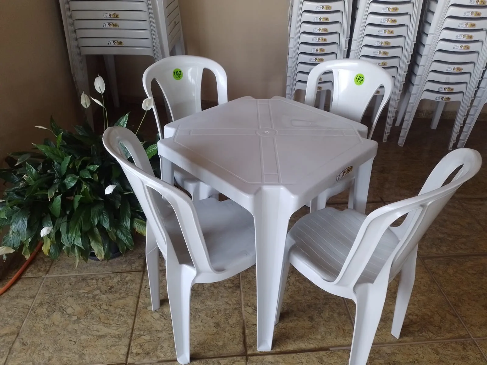 Jogo de mesa quadrada com quatro cadeiras plásticas brancas